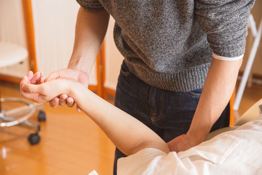 Clinician gently examining a patient’s arm
